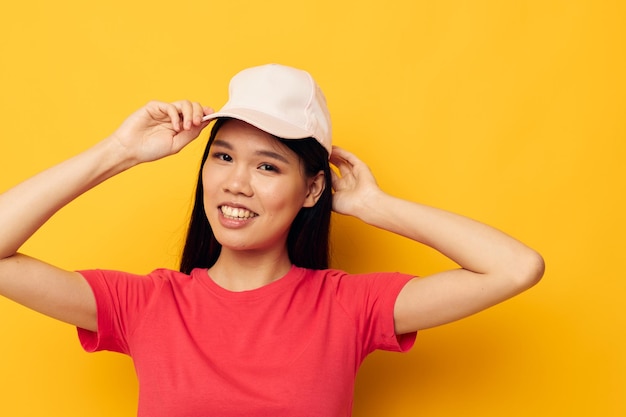 Vrolijke vrouw van Aziatische verschijning in een pet poseren