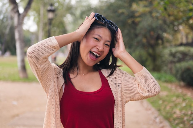 Vrolijke vrouw zet haar zonnebril op haar haar