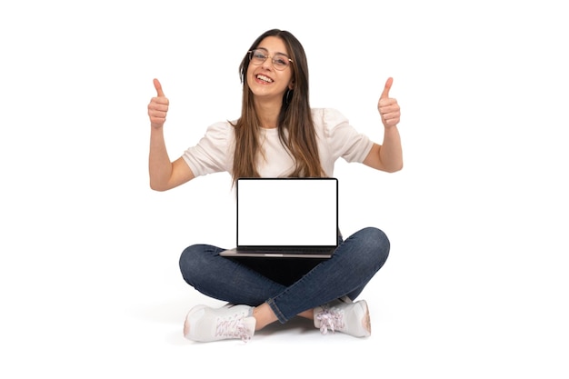 Vrolijke vrouw zittend op de grond met de computer op haar schoot die de website Thumb up aanbeveelt