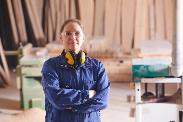 Vrolijke vrouwelijke productiemedewerker in blauwe overall