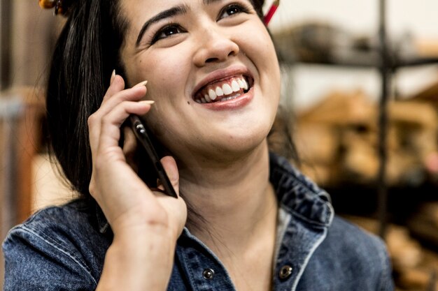 Vrolijke vrouwelijke timmerman praten aan een telefoon