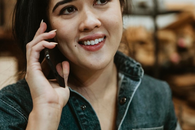 Vrolijke vrouwelijke timmerman praten aan een telefoon