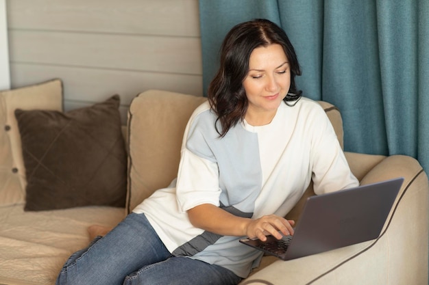 Vrouw 3540 jaar oud werkt op een laptop thuis online werk