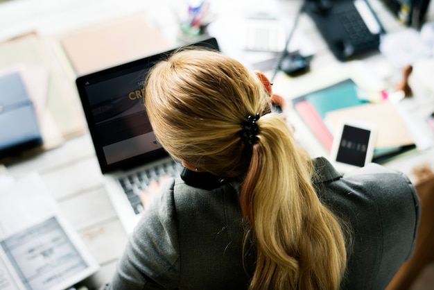 Vrouw aan de telefoon aan haar bureau