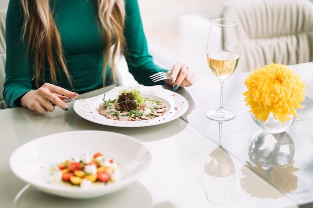 Vrouw aan het dineren in een restaurant. gezonde voeding levensstijl. zakelijk lunchconcept