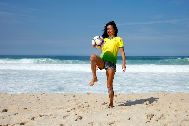 Vrouw aan het spelen met de bal op het strand