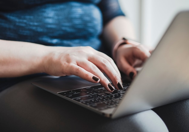 Vrouw aan het typen op haar laptop