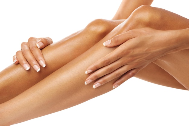 Vrouw aanraken benen huidverzorging en schoonheid voor wellness laser ontharing en geïsoleerde witte achtergrond Vrouwelijke handen been en studio huidverzorging van lichaamscosmetica glans en epileren voor esthetische salon