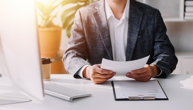 Vrouw accountant gebruikt rekenmachine en computer met pen aan