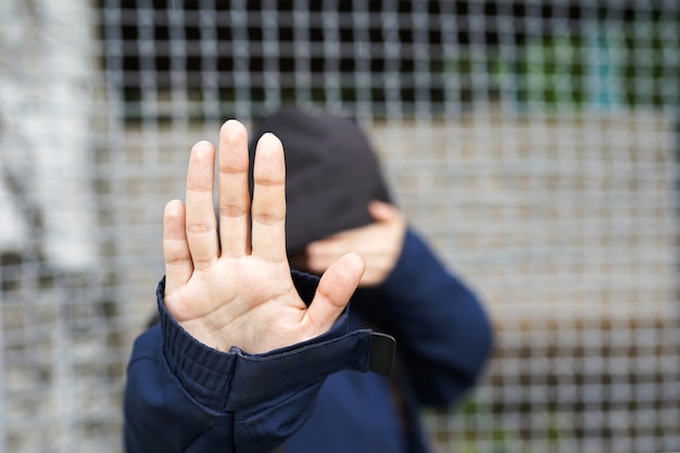 Vrouw achter het hek, close-up van de hand van een vluchteling