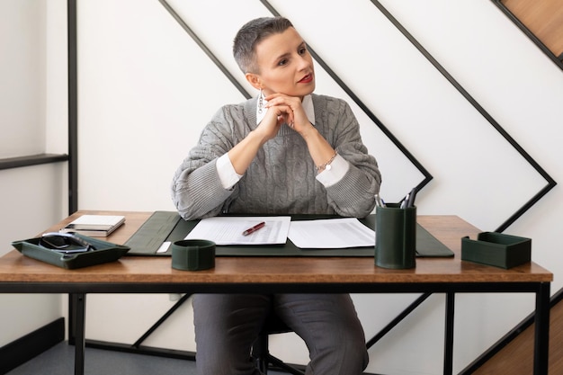 Vrouw advocaat op de werkplek aan een tafel met documenten zit na te denken