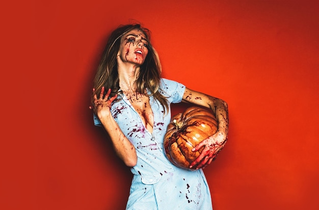 Vrouw als sexy vampierhalloween-concept eng bloedig zombiemeisje met pompoen vrouw met rood bloed a