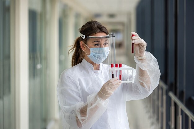 Vrouw arts bloedmonster in reageerbuis houden voor onderzoek in laboratorium