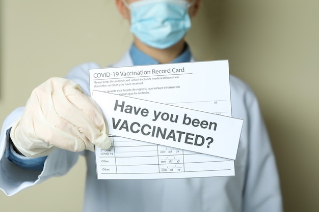 Foto vrouw arts in het bezit van vaccinatiebewijskaart en tekst bent u ingeënt?