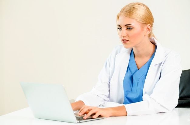 Vrouw arts in het ziekenhuis of gezondheidszorginstituut die aan medisch rapport bij bureaulijst werken.
