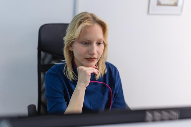 Vrouw arts in uniform werk met document in privékliniek Verpleegster zit achter bureau in kantoor medische geschiedenis of anamnese van cliënt te lezen die behandelplan leest