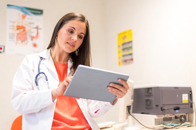 Vrouw arts werkzaam in het ziekenhuis met tablet