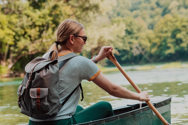 Vrouw avontuurlijke ontdekkingsreiziger kanovaren in een wilde rivier.