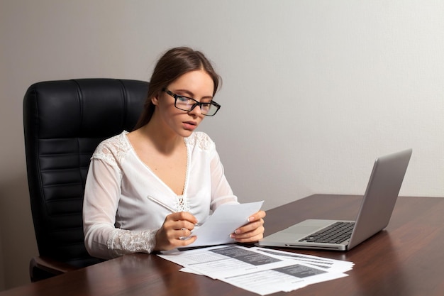 Vrouw baas leest documenten op kantoor