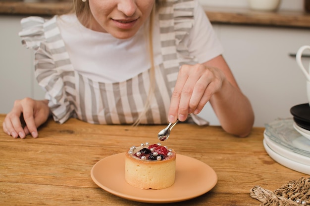 Vrouw banketbakker in schort versiert dessert