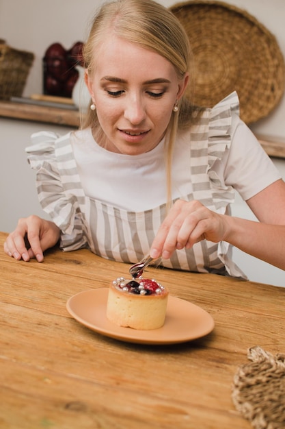 Vrouw banketbakker in schort versiert dessert