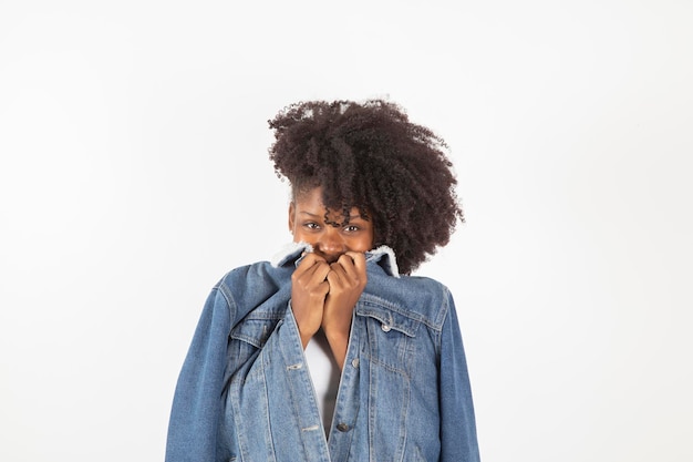 Vrouw bedekt haar glimlach met een jas op een witte achtergrond