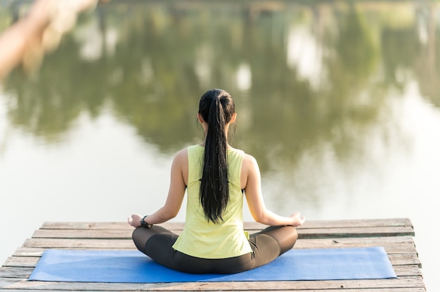 Vrouw beoefenen van yoga doet yoga in ochtendpark