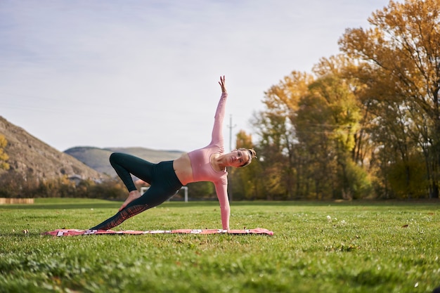 Vrouw beoefenen van yoga in het park - ontspannen in de natuur