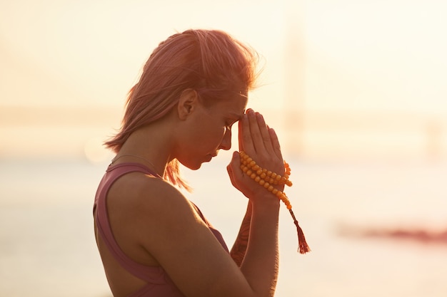 Vrouw beoefenen van yoga tijdens zonsondergang