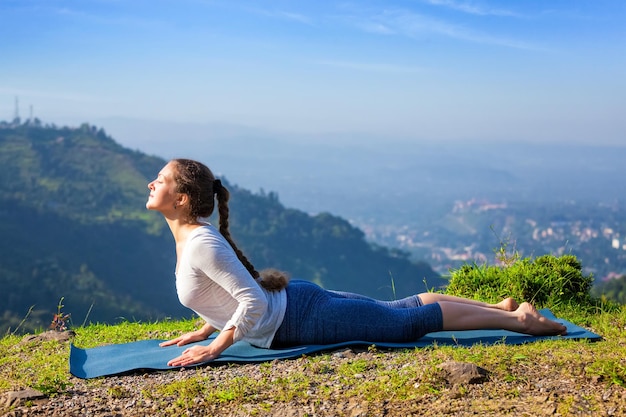 Vrouw beoefent yoga asana bhujangasana cobra pose