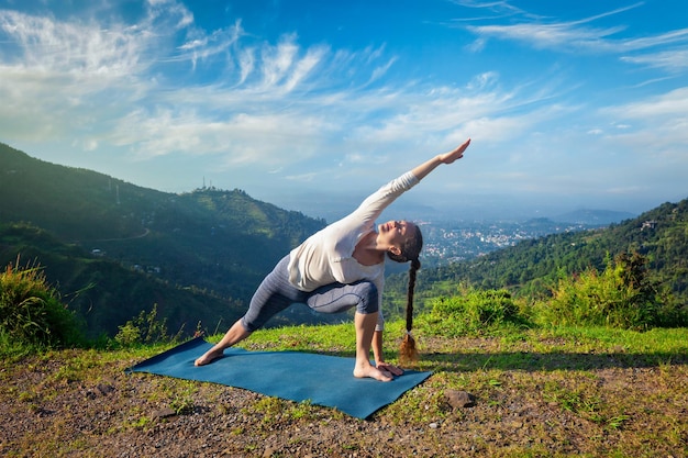 Vrouw beoefent yoga asana Utthita Parsvakonasana verlengde zijhoek pose buitenshuis
