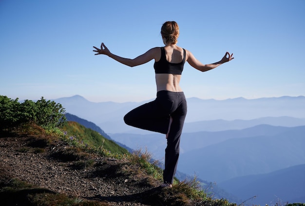 Vrouw beoefent yoga in de bergen