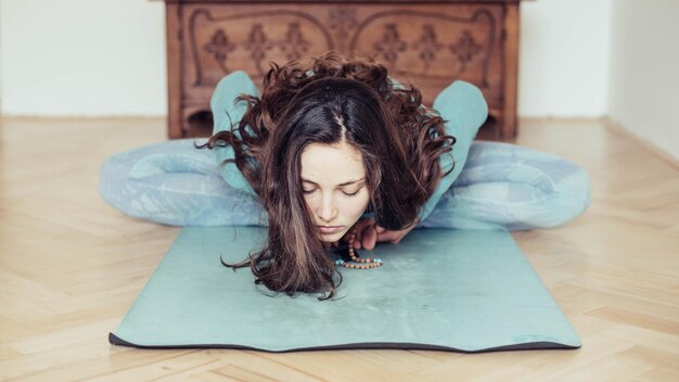 Foto vrouw beoefent yoga op een mat thuis