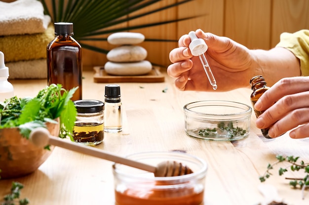 Foto vrouw bereidt aromatherapie sessie voor met essentiële olie diffuser medische kruiden en essences