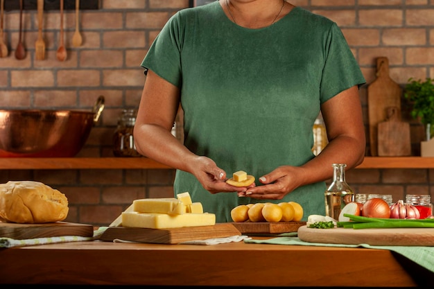 Vrouw bereidt Braziliaanse kaas gevulde kroket bolinha de queijo op een houten tafel