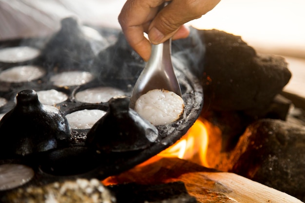 Vrouw bereidt kokosnoot Thaise desserts Kanom krok is een smakelijke Thaise minipannenkoekjes op basis van kokosmelk p