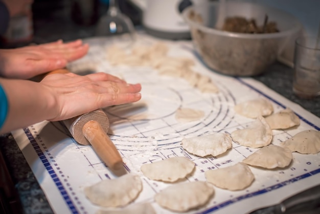 Vrouw bereidt pierogi in de keuken