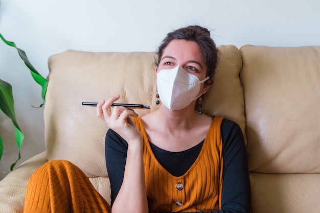 Vrouw besmet met coronavirusziekte die een vriend met telefoon belt. Blijf thuis. Pandemische virusziekte covid 19.