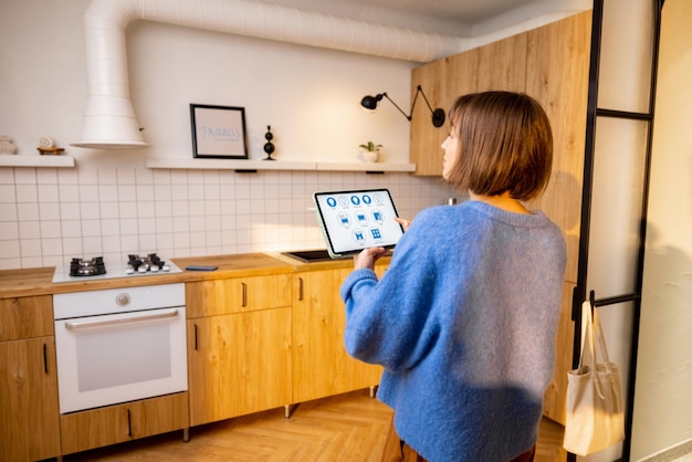 Vrouw bestuurt keukenapparatuur met een digitale tablet