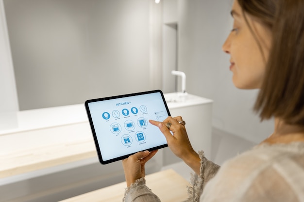 Vrouw bestuurt slimme keukenapparatuur met mobiel apparaat
