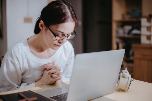 vrouw bidden voor laptop met aanbidding online