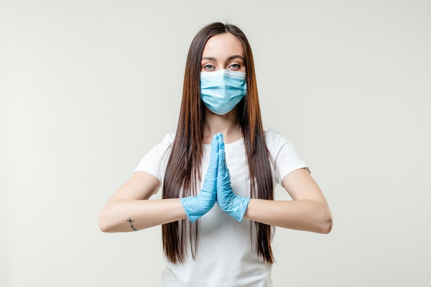 Foto vrouw biddend masker en handschoenen dragen