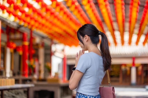 Vrouw bidt voor haar wensen in Chinese tempel