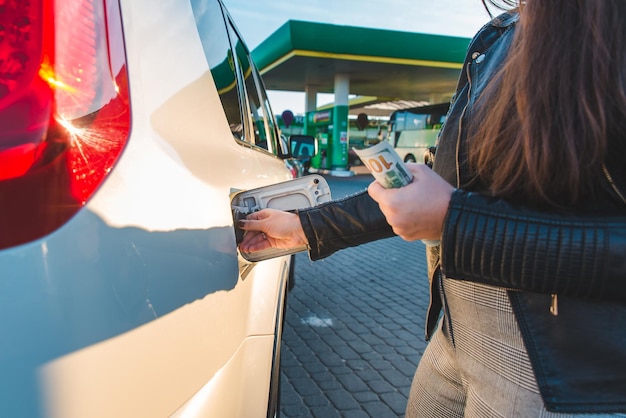 Foto vrouw bij benzinestation tankt prijsstijging auto bij