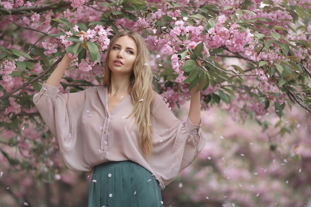 Vrouw bij bloeiende Sakura Tree op aard