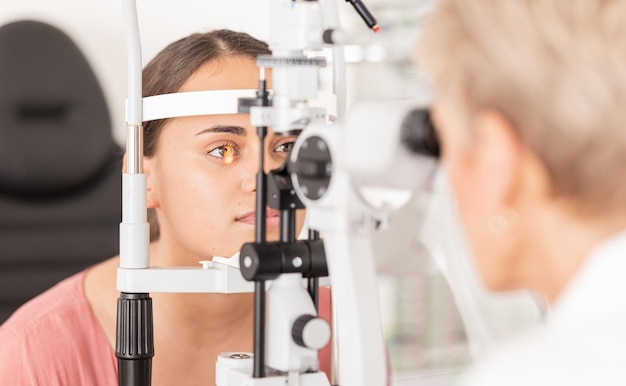 Vrouw bij ooglens test gezondheidszorg voor visie door opticien voor contactlens en focus met medische lasertool Gezichtsvermogen deskundige optometrist die glaucoompatiëntenverzekering en visuele zoom raadpleegt