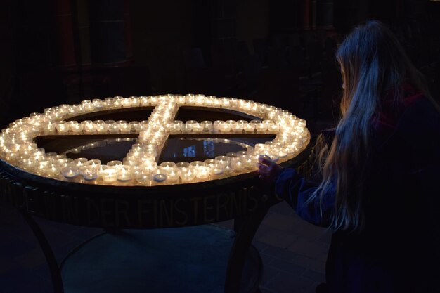 Foto vrouw bij verlichte thee kaarsen's nachts