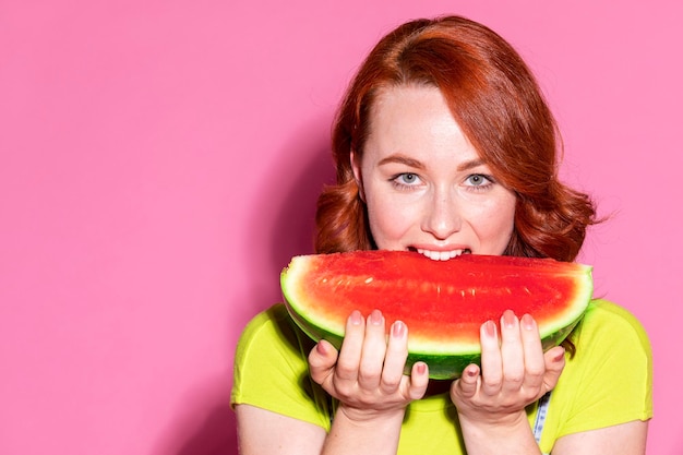 Vrouw bijt in een stuk watermeloen