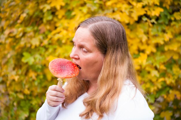 Vrouw bijt paddenstoel tegen planten