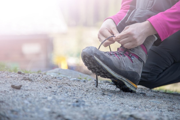 Vrouw bindt haar wandelschoenen vast en bereidt zich voor op een reis